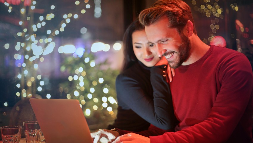 Couple doing online shopping for Christmas. E-commerce.