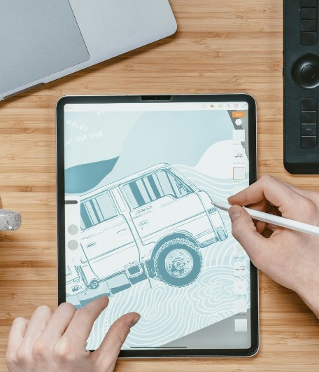Man designing a truck graphic on a tablet.