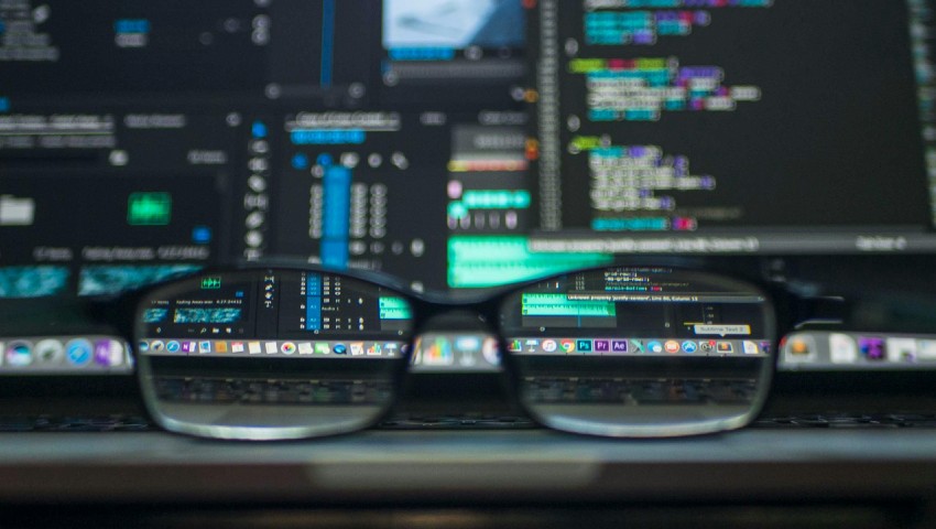 We develop - www.webfocus.ca Web development computer shown through glasses lens.